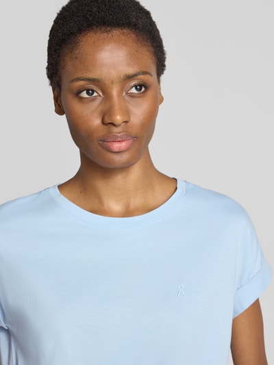 Frauenmodel trägt hellblaues Loose Fit T-Shirt aus reiner Baumwolle Modell 'IDAARA' von ARMEDANGELS, Damen T-Shirt, Nahaufnahme Oberkörper.