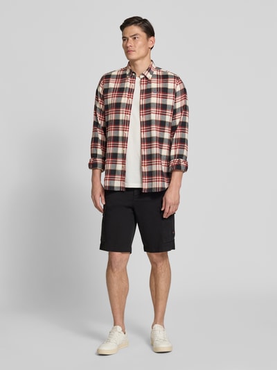Männermodel trägt Relaxed Fit Cargoshorts aus Baumwoll-Mix Modell 'SISLA' von BOSS Orange in Schwarz mit Taschen und Label Patch, Ganzkörperansicht von vorne.