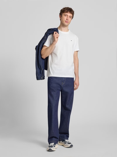 Männermodel trägt Regular Fit T-Shirt aus reiner Baumwolle von Tommy Jeans in Optik: Unifarben, Regular-Fit, Logo-Stitching, Rundhals, Kurzarm, Jersey; Ganzkörperansicht von vorne.
