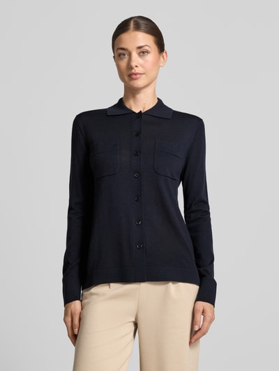 Frauenmodel trägt Strickjacke aus reiner Schurwolle Modell 'DETTO' von MM by Max Mara, dunkelblau, glatte Textur, Nahaufnahme Oberkörper.