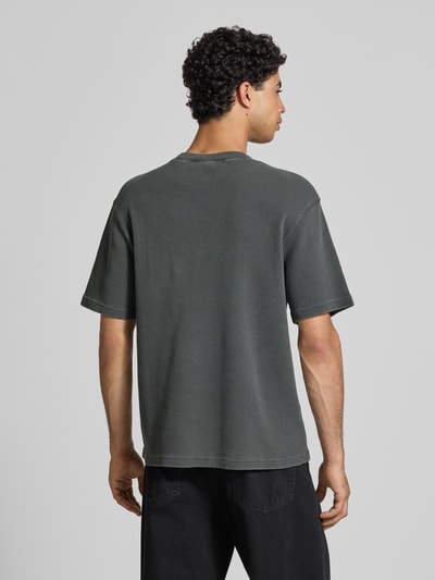 Männermodel trägt Herren T-Shirt mit Strukturmuster Modell 'Nelson' von Carhartt Work In Progress aus Reine Baumwolle im Relaxed-Fit, Rückenansicht Ganzkörperansicht.