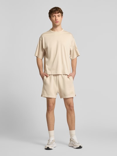 Männermodel trägt Regular Fit T-Shirt aus reiner Baumwolle von adidas Sportswear, Optik: Unifarben, Logo-Print, Rundhals, Kurzarm, Jersey, Ganzkörperansicht von vorne.