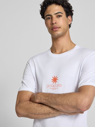 Männermodel trägt weißes Regular Fit T-Shirt mit orangefarbenem Logo-Print Modell 'Eres' von Jack & Jones, Nahaufnahme Oberkörper.