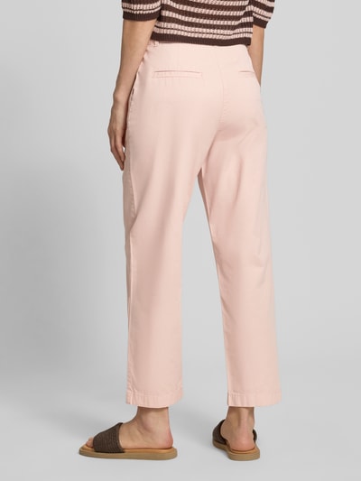 Frauenmodel trägt Chino mit Paspeltaschen am Gesäß von Jake*s Casual in zartem Rosa, Relaxed-Fit, verkürzte Passform, Ganzkörperansicht Rückansicht. Bundweite bei Größe 36: 37 cm, Innenbeinlänge bei Größe 36: 68 cm, mit Eingrifftaschen und Paspeltaschen am Gesäß.