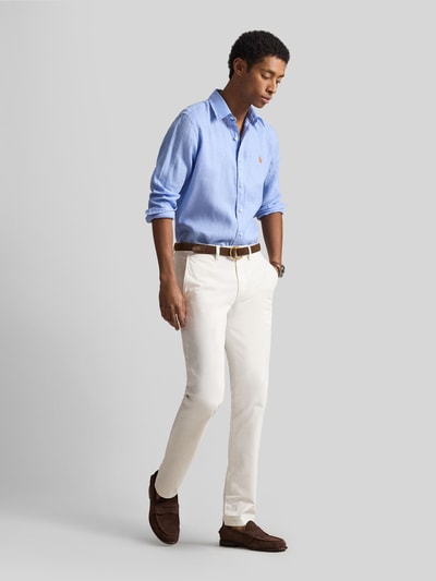 Männermodel trägt Slim Fit Freizeithemd aus reinem Leinen von Polo Ralph Lauren in Optik: Unifarben, Flammgarn-Textur, Ganzkörperansicht von vorne.