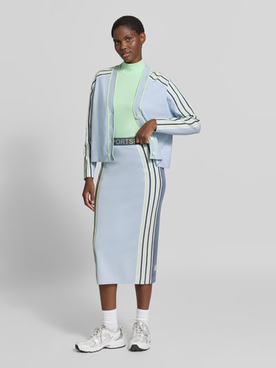 Frauenmodel trägt Midirock aus Lyocell-Mix von Marc Cain, Damen Midirock mit Statement-Print in Hellblau und Grün, gerade Passform, elastischer Bund, Ganzkörperansicht von vorne.