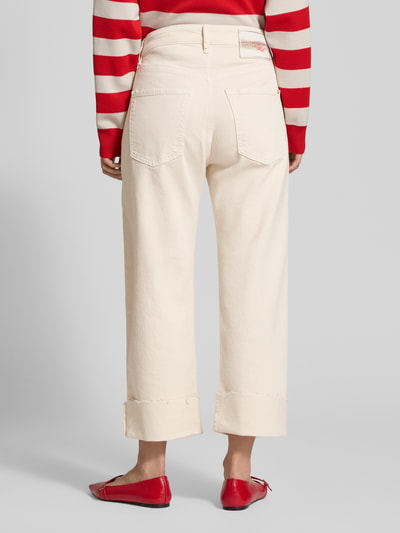 Frauenmodel trägt Baggy Fit Jeans aus Baumwoll-Mix von MAC in Creme mit geradem Bein, metallischen Nieten, Label-Patch, ausgefranster Saum, Ganzkörperansicht Rückansicht.