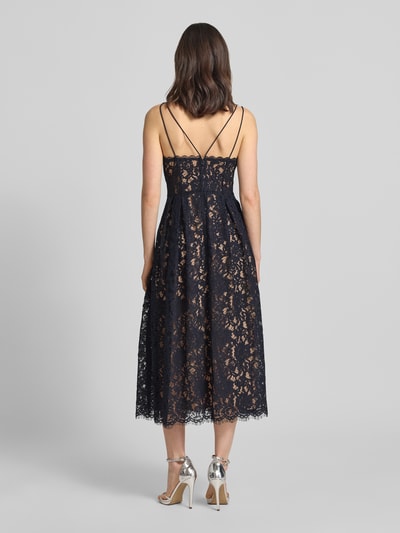 Modelka nosi knielanges Cocktailkleid mit Spitze und Spaghettiträgern od Jake*s Cocktail, mieszanka bawełny, taliowany, długość do kolan, koronka, podwójne cienkie ramiączka, dekolt w serek, zapięcie na haftkę i zamek błyskawiczny z tyłu, nieprzezroczysta halka, długość tyłu w rozmiarze 36: 123 cm, szerokość w rozmiarze 36: 34 cm, ciemny kolor, koronkowa faktura. Widok całej sylwetki od tyłu.