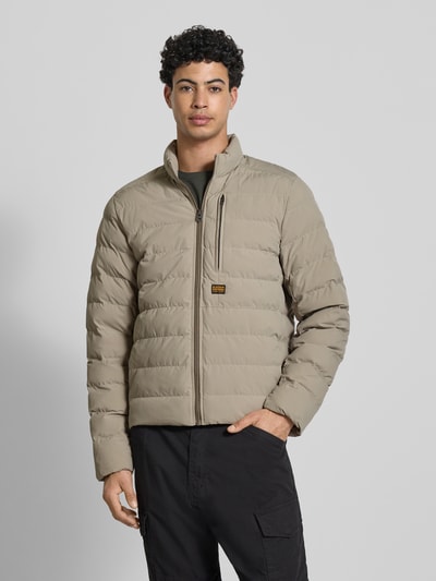 Männermodel trägt Regular Fit Steppjacke mit Logo-Patch Modell 'Foundation' von G-Star Raw, beige, Stepp-Optik, Nahaufnahme Oberkörper, gefütterter Stehkragen, Napoleon-Tasche, Reißverschluss, Rückenlänge M 71 cm, Schulterbreite 43 cm, Brustweite 57 cm, Ärmellänge 74 cm