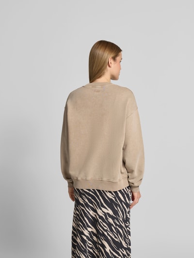 Frauenmodel trägt Oversized Sweatshirt mit Motiv-Print von Lala Berlin in Beige aus reiner Baumwolle, Oversized-Fit, elastische Abschlüsse, Rückenlänge bei Größe S 56 cm, Ganzkörperansicht Rückansicht.