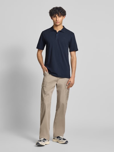 Männermodel trägt Regular Fit Poloshirt aus reiner katoen model 'Core' van G-Star Raw in donkerblauw met labeldetail, heren poloshirt, ruglengte bij maat M 72 cm, ganzkörperansicht van voren.