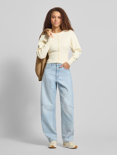 Modelka nosi Slim Fit Cardigan aus Viskose-Mix od Gina Tricot, krój regular fit, dzianinowa faktura, okrągły dekolt, długość tyłu 48 cm, długość rękawa 59 cm, szerokie elastyczne ściągacze, pełny widok z przodu
