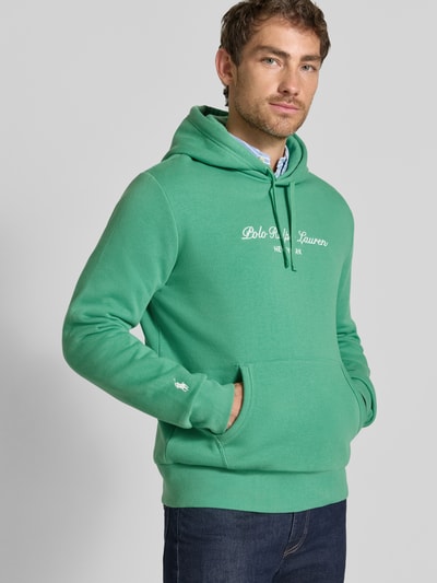 Mężczyzna nosi Relaxed Fit Hoodie aus Baumwoll-Mix od Polo Ralph Lauren, zielony kolor, gładka tekstura, Ganzkörperansicht von vorne.