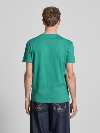 Männermodel trägt Regular Fit T-Shirt aus reiner Baumwolle von Tommy Jeans in Unifarben, Jersey, Rundhals, Kurzarm, Ganzkörperansicht Rückansicht.