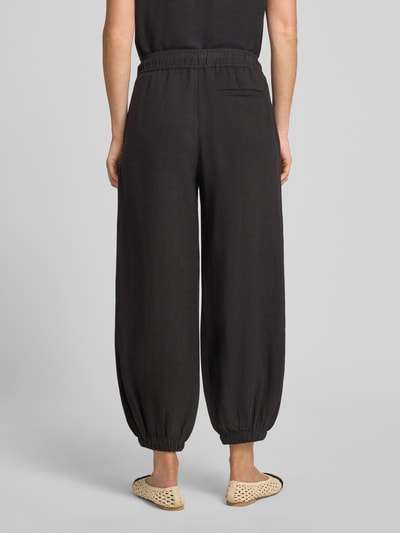 Vrouwenmodel draagt Relaxed Fit broek uit viscosemix model 'Myha' van OPUS, zwart, elastische band met tunnelkoord, steekzakken, verkorte pasvorm, elastische boorden, mix van viscose en linnen, binnenbeenlengte 68 cm, bandwijdte maat 36: 38 cm, geheel achteraanzicht.