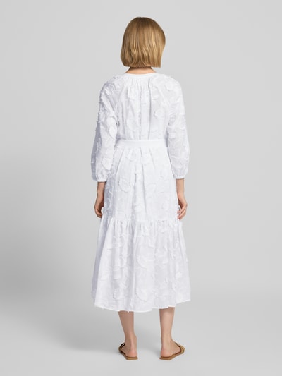 Vrouwenmodel draagt Relaxed Fit midi-jurk met florale siergarnering van comma, Materiaalmix met katoenmix, Tuniekhals, 3/4-mouw, doorlopende knoopsluiting, ruglengte bij maat 36: 119 cm, borstwijdte bij maat 36: 60 cm, mouwlengte bij maat 36: 47 cm, witte kleur, bloemenstructuur, Ganzkörperansicht Rückansicht.
