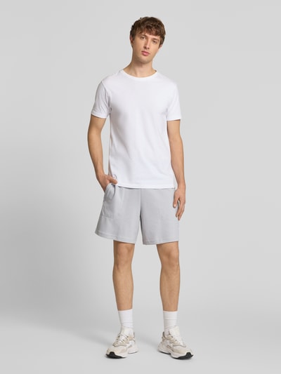 Männermodel trägt Regular Fit Sweatshorts mit Baumwoll-Anteil von adidas Originals, Optik: Unifarben, Waffelstruktur, Logo-Stitching, Tunnelzug innen, Bundabschluss: elastisch, mit seitlichen Eingrifftaschen, Ganzkörperansicht von vorne.