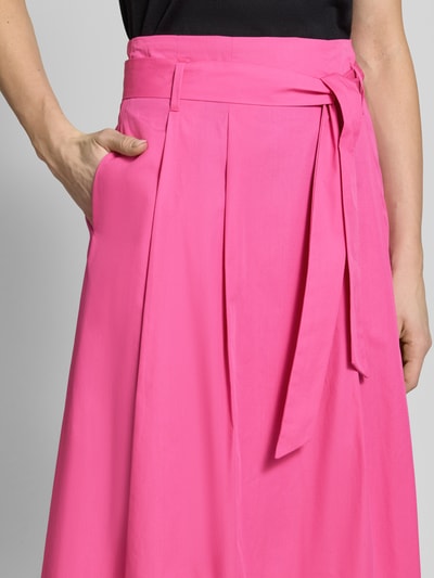 Vrouwenmodel draagt Regular Fit midirok in plooien-look van Christian Berg Woman van puur katoen met ritssluiting en afneembare stoffen band, detailopname taille