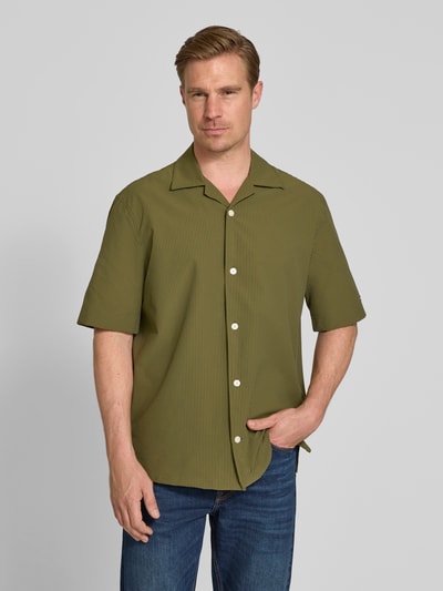 Männermodel trägt Relaxed Fit Freizeithemd aus Seersucker-Material von Tommy Hilfiger, Optik:Allover-Muster, Kurzarm, Ganzkörperansicht von vorne.