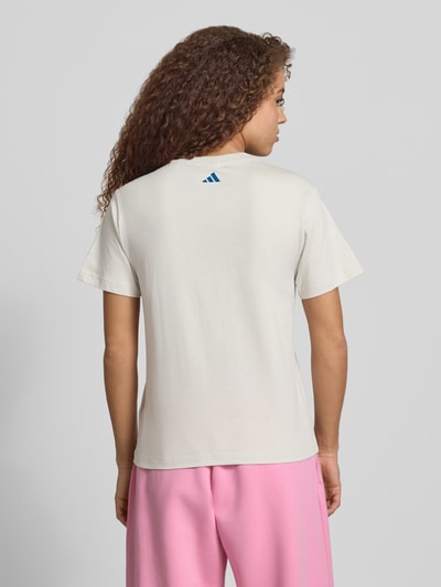 Vrouwenmodel draagt T-shirt met Label-Print van adidas Sportswear in gebroken wit, puur katoen, regular fit, ruglengte maat S 61 cm, volledige rugaanzicht.
