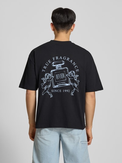 Männermodel trägt T-Shirt mit Logo-Print und Rundhalsausschnitt von REVIEW, schwarze Reine Baumwolle, Loose-Fit, Rückenlänge 69 cm, Ganzkörperansicht Rückansicht.