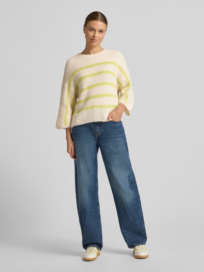 Frauenmodel trägt Strickpullover mit 3/4-Ärmel von Rich & Royal im Alpaka-Mix, lockerer Schnitt, gelbe Streifen, Ganzkörperansicht von vorne.