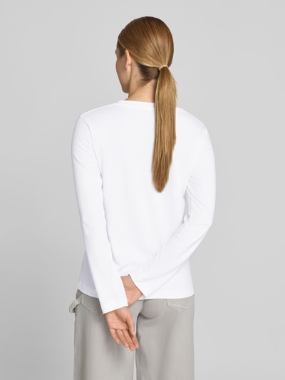 Frauenmodel trägt Longsleeve mit Rundhalsausschnitt von Juvia in Weiß aus Baumwoll-Mix, Gerader-Schnitt, langärmlig, Rückenlänge 60 cm, Ganzkörperansicht Rückansicht.