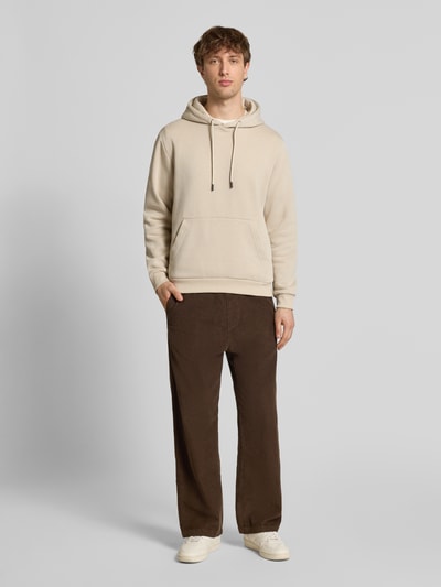 Männermodel trägt Hoodie mit Kapuze Modell 'BRADLEY' von Jack & Jones in Beige, lockerer Schnitt, Baumwoll-Mix, Ganzkörperansicht von vorne.