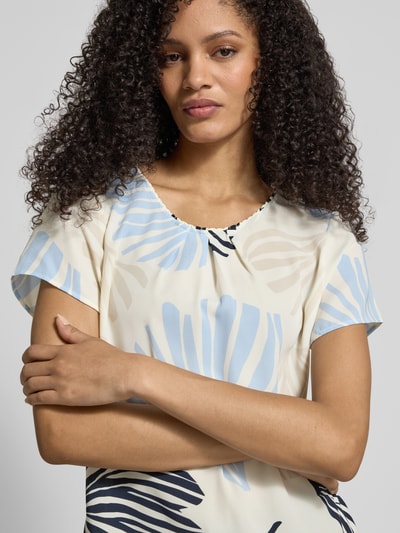 Frauenmodel trägt Loose Fit Blusenshirt mit Allover-Muster von s.Oliver BLACK LABEL, Chiffon, Rundhals, gelegte Falten, Kurzarm, Nahaufnahme Oberkörper.