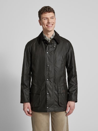Männermodel trägt Original Wachsjacke von Barbour in Dunkelbraun mit gewachster Oberfläche, Cordkragen, Außentaschen, Ganzkörperansicht von vorne.