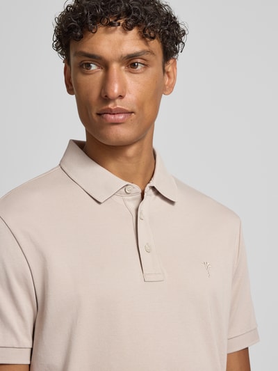 Männermodel trägt Modern Fit Poloshirt mit Logo-Stitching Modell 'Primo' von JOOP! Collection in Beige, reine Baumwolle, Nahaufnahme Oberkörper.