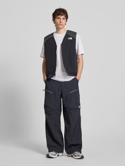 Männermodel trägt Relaxed Fit T-Shirt mit Logo-Print von The North Face in Weiß, reine Baumwolle, Rundhalsausschnitt, Ganzkörperansicht von vorne.
