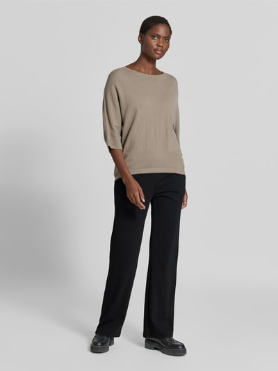 Frauenmodel trägt Flared Fit Sweatpants mit Tunnelzug von Juvia in Schwarz, strukturierte Baumwoll-Modal-Mix Optik, Ganzkörperansicht von vorne.