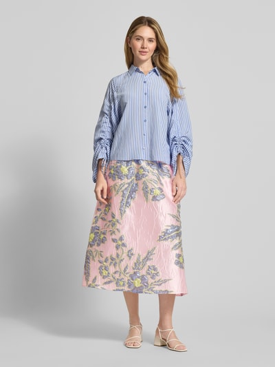 Kobiece model prezentuje Regular Fit Midirock mit floralem Allover-Stitching von Milano Italy, satyna, linia A, elastyczny pas, szerokość w rozmiarze 36: 36 cm, całkowita długość w rozmiarze 36: 83 cm, kwiatowy haft, pastelowe kolory, widok całej sylwetki z przodu.