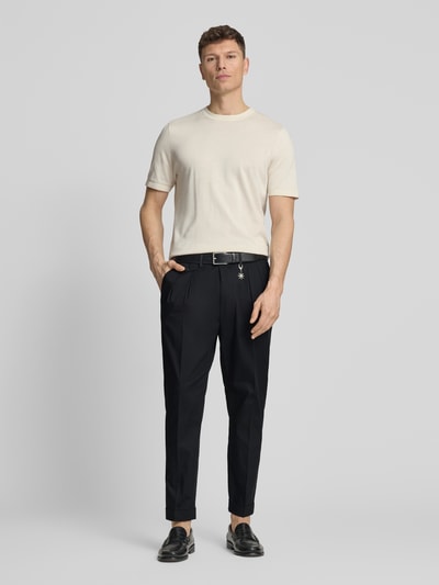 Männermodel trägt Hose mit gelegten Falten und Eingrifftaschen von Manuel Ritz aus dunkelblauem Baumwoll-Mix mit Stretch-Anteil, Regular-Fit, Bundweite 50 cm, Innenbeinlänge 72 cm, Label-Detail, Ganzkörperansicht von vorne.