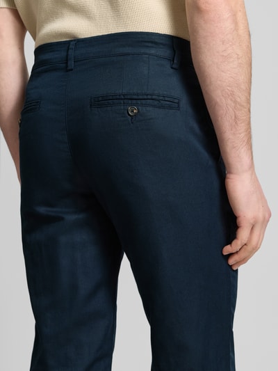Męski model nosi Regular Fit Leinenhose aus Baumwoll-Leinen-Mix Modell 'MILES' von SELECTED HOMME, efekt: jednolity kolor, mieszanka bawełny i lnu, 5 kieszeni, krój regular fit, średni stan, zapięcie na guzik i ukryty zamek błyskawiczny. Detailaufnahme tylnej części.