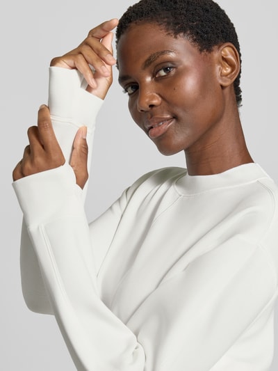 Frauenmodel trägt Cropped Sweatshirt Modell 'tasmin' von VARLEY, weiß, lockere Passform, Daumenschlaufen, Nahaufnahme Oberkörper. Modal-Mix mit Stretch-Anteil.