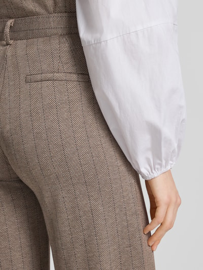 Frauenmodel trägt Straight Fit Hose mit Viskose-Anteil Modell 'Bonnie' von FREE/QUENT in braunem Fischgrätmuster, Detailaufnahme, elastischer Material-Mix.