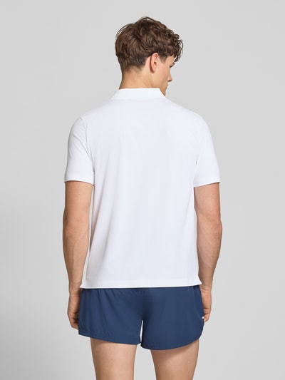Männermodel trägt weißes Slim Fit Poloshirt mit Logo Modell 'EDMOND' von Ellesse, Material-Mix mit Stretch-Anteil, Rückenlänge 63 cm, Ganzkörperansicht Rückansicht.
