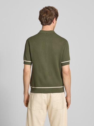 Männermodel trägt Slim Fit Strick-Poloshirt mit Label-Stitching von REVIEW in Oliv mit weißen Kontraststreifen, Viskose-Mix, Ganzkörperansicht Rückansicht.
