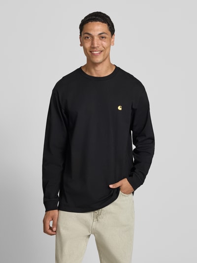 Mannenmodel draagt shirt met lange mouwen met labelstitching van Carhartt Work In Progress, puur katoen, relaxed fit, ronde hals, ruglengte maat M 66 cm, Ganzkörperansicht von vorne.