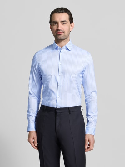 Männermodel trägt Slim Fit Businesshemd mit Kentkragen von Jake*s, hellblau-weiß gestreift, elastisch, Knopfleiste, Ganzkörperansicht von vorne.