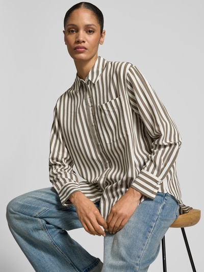 Frauenmodel trägt Relaxed Fit Hemdbluse aus Viskose-Mix von comma mit Streifenmuster, Hemdblusenkragen, Brusttasche, Knopfleiste, verlängerte Rückseite, Langarm, Ganzkörperansicht von vorne.