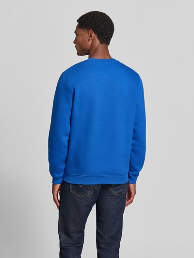 Męski model ma na sobie Sweatshirt aus Baumwoll-Mix od MCNEAL, intensywny niebieski kolor, wyhaftowane logo, prążkowane wykończenia, okrągły dekolt, luźny krój, długość tyłu 67 cm, długość rękawa 65 cm, mieszanka bawełny, Ganzkörperansicht Rückansicht.