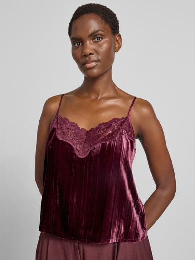 Frauenmodel trägt Blusentop mit verstellbaren Spaghettiträgern von Jake*s Casual in dunklem Rot, glänzende Plissee-Optik, Nahaufnahme Oberkörper.