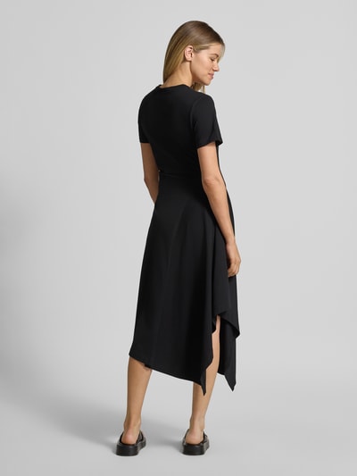 Vrouwenmodel draagt Tailliertes Jersey-Kleid aus Baumwoll-Mix van s.Oliver RED LABEL in zwart, getailleerde fit, asymmetrische zoom, hele lichaamsweergave van achteren.