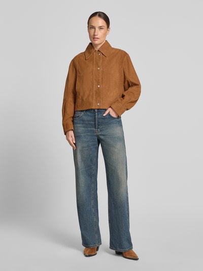 Kobiece model prezentuje kurtka skórzana Regular Fit Lederjacke aus echtem Ziegenleder Modell 'C_SALISA 60' od BOSS Orange w kolorze brązowym oraz niebieskie spodnie dżinsowe, matowa faktura, Ganzkörperansicht von vorne.