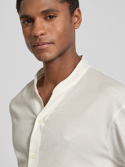 Männermodel trägt Regular Fit Freizeithemd mit V-Ausschnitt und Label-Stitching von Emporio Armani aus reiner Baumwolle, Nahaufnahme Oberkörper.