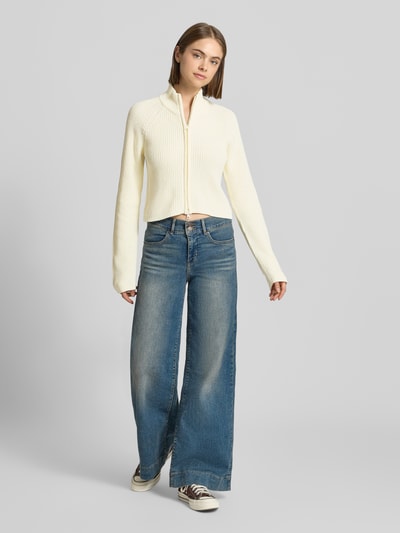 Frauenmodel trägt Slim Fit Jacke aus Baumwoll-Mix Modell 'Dara' von NOISY MAY®, cremefarben mit Stehkragen, Zweiwege-Reißverschluss, Ganzkörperansicht von vorne.