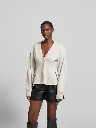 Frauenmodel trägt Cardigan mit Kaschmir-Anteil von ROTATE in Beige, Baumwoll-Mix, tailliert, Strick-Optik, V-Ausschnitt, Kellerfalten, Ganzkörperansicht von vorne.